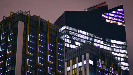 Night architecture, skyscrapers with glass facade. Modern buildings in business district. Concept of economics, financial.の写真素材