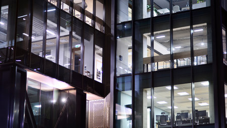 A modern architectural design intricately with details. Night lights casting reflections, capturing the essence of contemporary art and advanced engineering.の写真素材