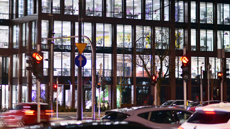 Warsaw, Poland. 21 November 2024. Street photography of cars on the street at night. The light trails on the modern building background.のeditorial素材