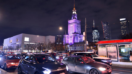 Warsaw, Poland. 22 November 2024. Street photography of cars on the street at night. The light trails on the modern building background.のeditorial素材