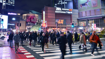 Warsaw, Poland. 22 November 2024. Street of a big city. People of different ages crossing the road through. View of a city street with residents, tourists and modern buildings.のeditorial素材