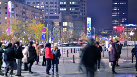 Warsaw, Poland. 22 November 2024. Street photography of people on the street at night. The pedestrian silhouettes on the modern building background. Motion blur of people. Urbanのeditorial素材