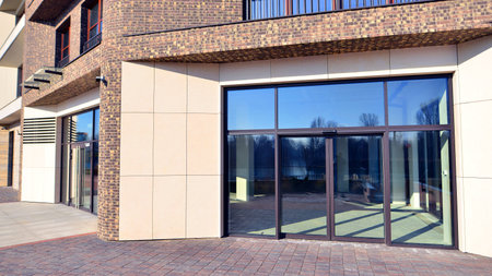 View of a modern commercial premises with a large glass front on a very bright day. New commercial premises waiting to be rented.の写真素材