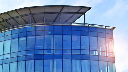 Modern stylish architecture. Symmetrical blue glass building in the city. Cityscape office buildings with modern corporate architecture - business and success concept.の写真素材