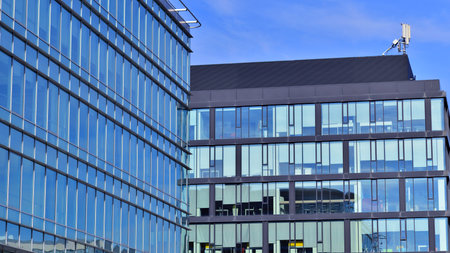 Modern stylish architecture. Symmetrical blue glass building in the city. Cityscape office buildings with modern corporate architecture - business and success concept.の写真素材