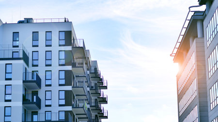 View of an modern apartment building standing next to a new modern office building with a glass facade.の写真素材