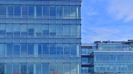 Modern stylish architecture. Symmetrical blue glass building in the city. Cityscape office buildings...