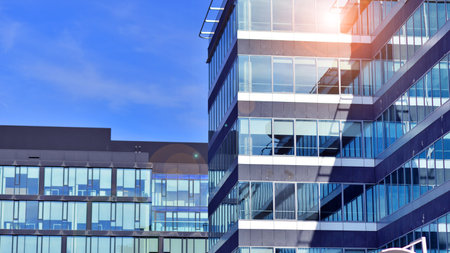 Modern stylish architecture. Symmetrical blue glass building in the city. Cityscape office buildings with modern corporate architecture - business and success concept.の写真素材