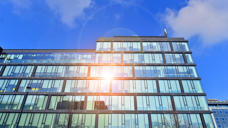 Cityscape office buildings with modern corporate architecture - business and success concept. Modern stylish architecture. Symmetrical blue glass building in the city.の写真素材
