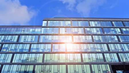 Cityscape office buildings with modern corporate architecture - business and success concept. Modern stylish architecture. Symmetrical blue glass building in the city.の写真素材