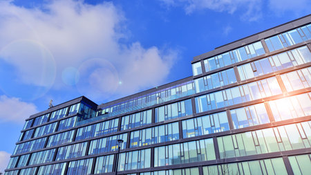 Cityscape office buildings with modern corporate architecture - business and success concept. Modern stylish architecture. Symmetrical blue glass building in the city.の写真素材