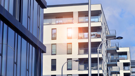 View of an modern apartment building standing next to a new modern office building with a glass facade.の写真素材