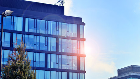 Cityscape office buildings with modern corporate architecture - business and success concept. Modern stylish architecture. Symmetrical blue glass building in the city.の写真素材