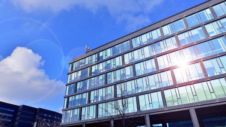 Cityscape office buildings with modern corporate architecture - business and success concept. Modern stylish architecture. Symmetrical blue glass building in the city.の写真素材
