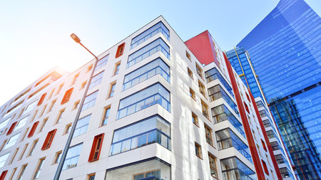 View of a modern apartment building standing next to a new modern office building with a glass facade.の写真素材