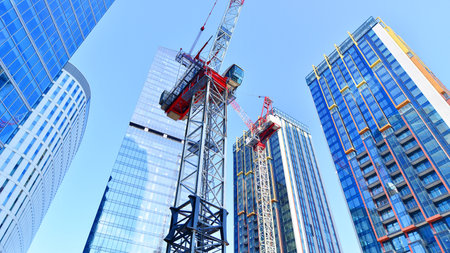 Crane on the construction site in a site surrounded by the high buildings.の写真素材