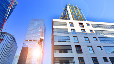 View of an modern apartment building standing next to a new modern office building with a glass facade.の写真素材