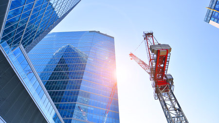 Crane on the construction site in a site surrounded by the high buildings.の写真素材