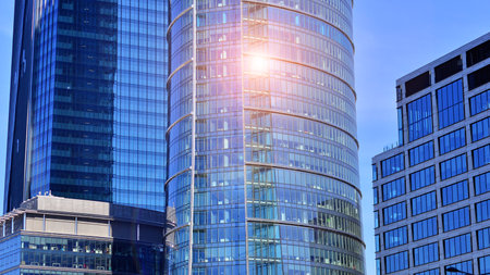 Glass building with transparent facade of the building and blue sky. Structural glass wall reflecting blue sky. Abstract modern architecture fragment. Contemporary architecturalの写真素材
