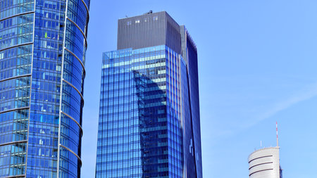 Glass building with transparent facade of the building and blue sky. Structural glass wall reflecting blue sky. Abstract modern architecture fragment. Contemporary architecturalの写真素材