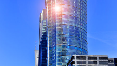 Glass building with transparent facade of the building and blue sky. Structural glass wall reflecting blue sky. Abstract modern architecture fragment. Contemporary architecturalの写真素材