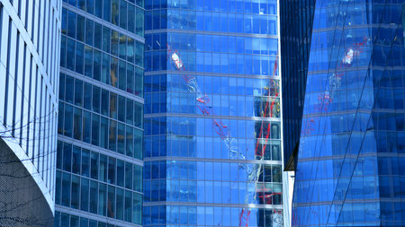 Glass building with transparent facade of the building and blue sky. Structural glass wall reflecting blue sky. Abstract modern architecture fragment. Contemporary architecturalの写真素材