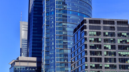 Glass building with transparent facade of the building and blue sky. Structural glass wall reflecting blue sky. Abstract modern architecture fragment. Contemporary architecturalの写真素材