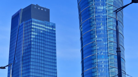Glass building with transparent facade of the building and blue sky. Structural glass wall reflecting blue sky. Abstract modern architecture fragment. Contemporary architecturalの写真素材