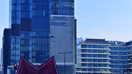Glass building with transparent facade of the building and blue sky. Structural glass wall reflecting blue sky. Abstract modern architecture fragment. Contemporary architecturalの写真素材