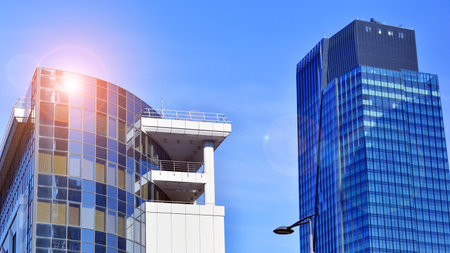 Glass building with transparent facade of the building and blue sky. Structural glass wall reflecting blue sky. Abstract modern architecture fragment. Contemporary architecturalの写真素材