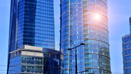 Glass building with transparent facade of the building and blue sky. Structural glass wall reflecting blue sky. Abstract modern architecture fragment. Contemporary architecturalの写真素材