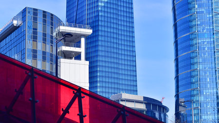 Glass building with transparent facade of the building and blue sky. Structural glass wall reflecting blue sky. Abstract modern architecture fragment. Contemporary architecturalの写真素材