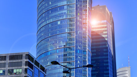 Glass building with transparent facade of the building and blue sky. Structural glass wall reflecting blue sky. Abstract modern architecture fragment. Contemporary architecturalの写真素材