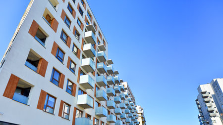 Apartment building with symmetrical modern architecture in the city. Modern apartment building on a sunny day. Facade of a modern apartment building. Bottom view.の写真素材