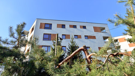 Apartment building with symmetrical modern architecture in the city. Modern apartment building on a sunny day. Facade of a modern apartment building. Bottom view.の写真素材