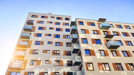 Apartment building with symmetrical modern architecture in the city. Modern apartment building on a sunny day. Facade of a modern apartment building. Bottom view.の写真素材