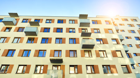 Apartment building with symmetrical modern architecture in the city. Modern apartment building on a sunny day. Facade of a modern apartment building. Bottom view.の写真素材