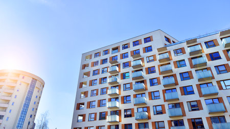 Apartment building with symmetrical modern architecture in the city. Modern apartment building on a sunny day. Facade of a modern apartment building. Bottom view.の写真素材