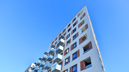 Apartment building with symmetrical modern architecture in the city. Modern apartment building on a sunny day. Facade of a modern apartment building. Bottom view.の写真素材