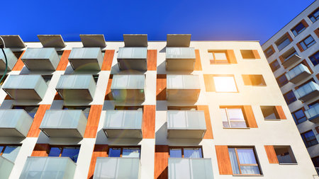 Apartment building with symmetrical modern architecture in the city. Modern apartment building on a sunny day. Facade of a modern apartment building. Bottom view.の写真素材