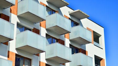 Apartment building with symmetrical modern architecture in the city. Modern apartment building on a sunny day. Facade of a modern apartment building. Bottom view.の写真素材