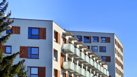 Apartment building with symmetrical modern architecture in the city. Modern apartment building on a sunny day. Facade of a modern apartment building. Bottom view.の写真素材