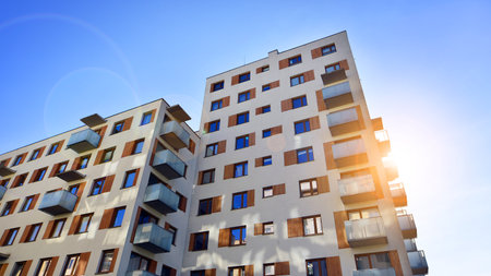 Apartment building with symmetrical modern architecture in the city. Modern apartment building on a sunny day. Facade of a modern apartment building. Bottom view.の写真素材