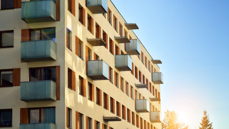 Apartment building with symmetrical modern architecture in the city. Modern apartment building on a sunny day. Facade of a modern apartment building. Bottom view.の写真素材