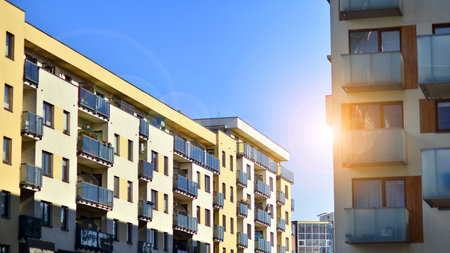 Apartment building with symmetrical modern architecture in the city. Modern apartment building on a sunny day. Facade of a modern apartment building. Bottom view.の写真素材