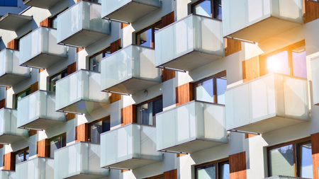 Apartment building with symmetrical modern architecture in the city. Modern apartment building on a sunny day. Facade of a modern apartment building. Bottom view.の写真素材