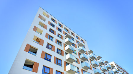Apartment building with symmetrical modern architecture in the city. Modern apartment building on a sunny day. Facade of a modern apartment building. Bottom view.の写真素材