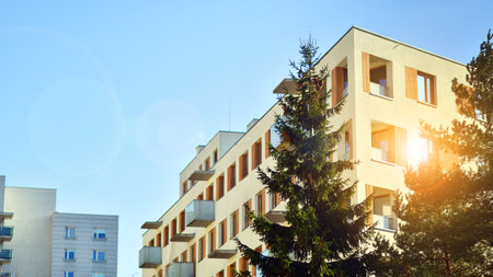 Apartment building with symmetrical modern architecture in the city. Modern apartment building on a sunny day. Facade of a modern apartment building. Bottom view.の写真素材