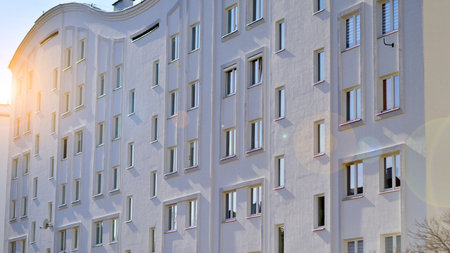 Apartment building with symmetrical modern architecture in the city. Modern apartment building on a sunny day. Facade of a modern apartment building. Bottom view.の写真素材