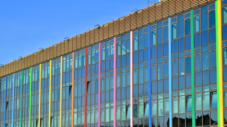 Structural glass wall reflecting blue sky. Abstract modern architecture fragment. Glass building with transparent facade of the building and blue sky. Contemporary architecturalの写真素材